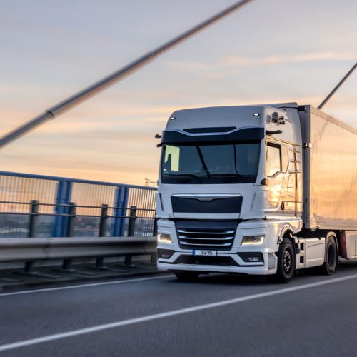 camion-bianco-che-attraversa-il-ponte-al-tramonto-logistica-urbana-movimento